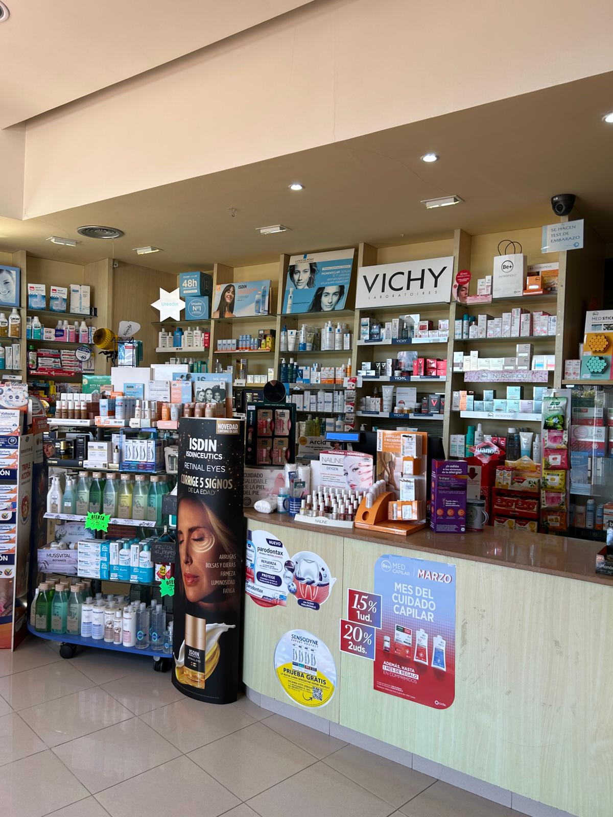 Interior de la farmàcia amb expositor de marques de dermocosmètica: Vichy, ISDIN, La Roche-Posay